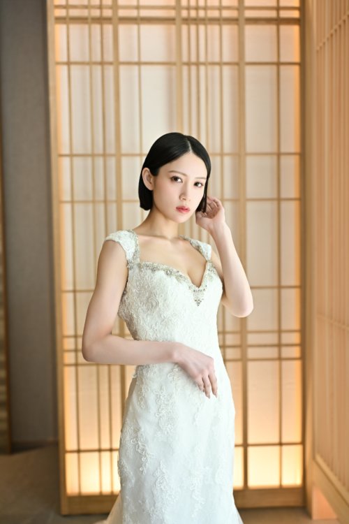 障子の前でスクエアネックのレースのウェディングドレスを着て髪に手を添える花嫁を縦位置でとらえた一枚。東京駅店のスタジオで撮る洋装前撮りのドレス写真