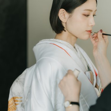 ヘアメイクリハーサル中にメモを取りながら確認する花嫁