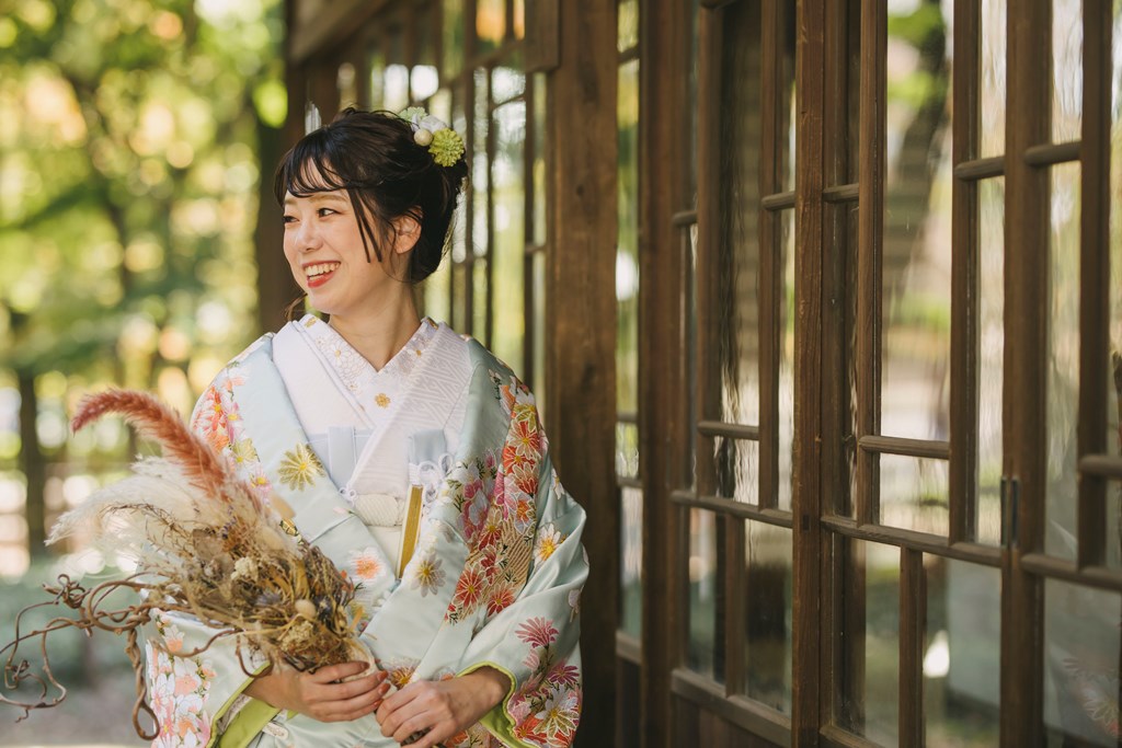 蘆花恒春園での色打掛前撮り、竹林または秋の紅葉を背景に色打掛の鮮やかな色彩が際立つ美しい一枚