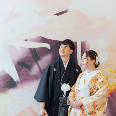 障子の部屋で新郎の肩に手を添える白無垢の花嫁と黒紋付袴の新郎。東京駅店のスタジオで撮る和装前撮り