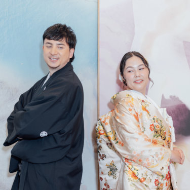 障子の部屋で拍手をして笑う黒紋付袴の新郎と白無垢の花嫁。東京駅店のスタジオで撮る和装前撮りの遊び心のあるカット