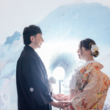 障子の前で白無垢の花嫁を抱き寄せる黒紋付袴の新郎を縦位置でとらえた一枚。東京駅店のスタジオで撮る和装前撮り