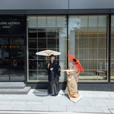 縦格子の障子の逆光の中で向かい合う黒紋付袴の新郎と白無垢の花嫁。東京駅店のスタジオで撮る和装前撮り