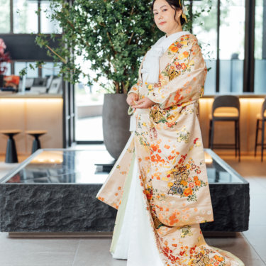 白い和傘の下で額を寄せ合う黒紋付袴の新郎と白無垢の花嫁。和傘を使った和装前撮りのポーズ