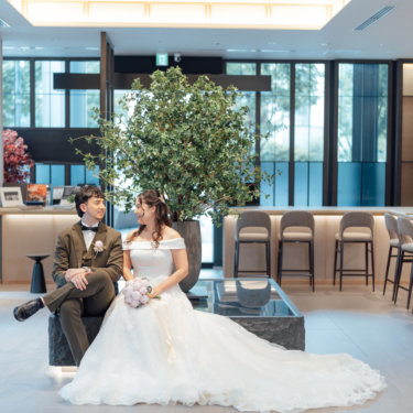 窓辺の障子の部屋で正座して笑う黒紋付袴の新郎と花柄の色打掛の花嫁。東京駅店のスタジオで撮る和装前撮り