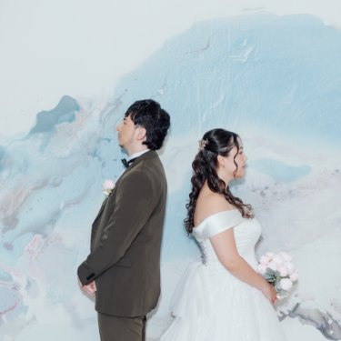 緑に囲まれた洋館の前で腕を組むベストの新郎とウェディングドレスの花嫁。洋館の庭で撮る洋装前撮り