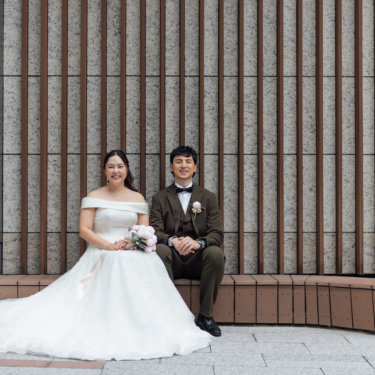 逆光の中で花嫁を抱き上げる白いジャケットの新郎とウェディングドレスの花嫁のシルエット。夕景で撮る洋装前撮りの抱き上げポーズ