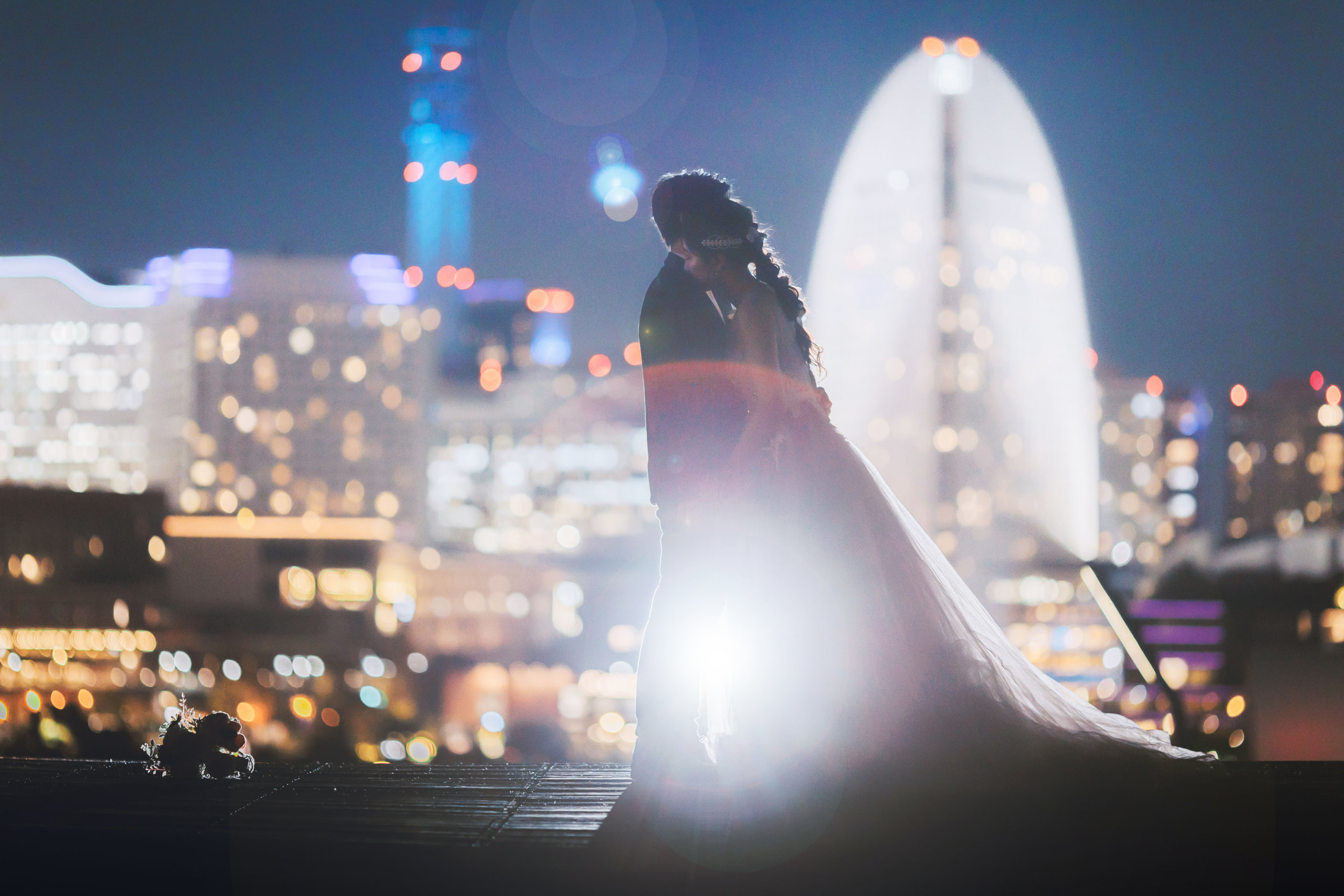 みなとみらいの夜景を背景に、シルエットで静かに寄り添う新郎新婦のナイトウェディングフォト
