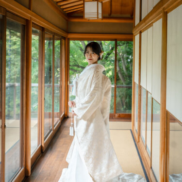 目白庭園の回廊で白無垢の裾を長く引いて振り返る花嫁の全身ポートレート。白無垢のバックスタイルが映える和装フォトウェディング