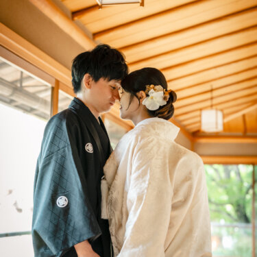 目白庭園の回廊でおでこを寄せ合う黒紋付袴の新郎と白無垢の花嫁。和装前撮りで人気のおでこ合わせポーズ